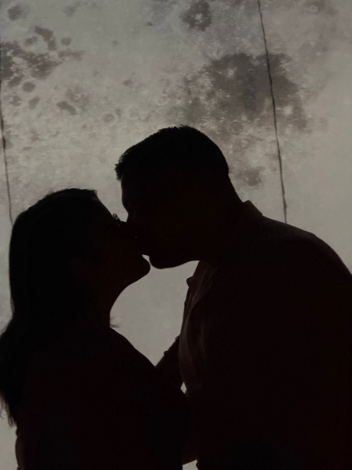 Siluetas de una pareja frente a la luna