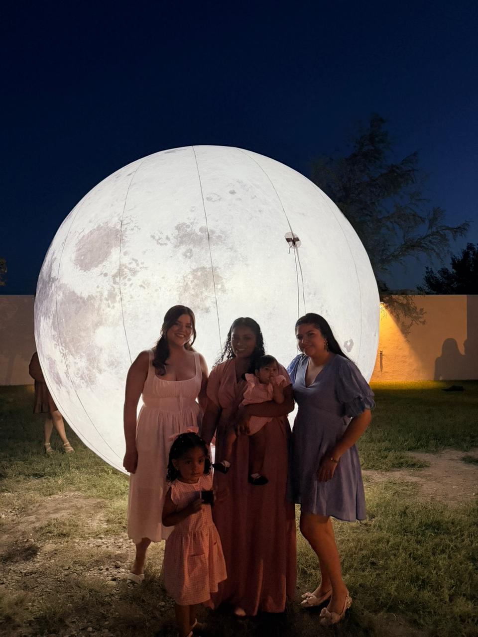 Una familia posando frente a la luna iluminada